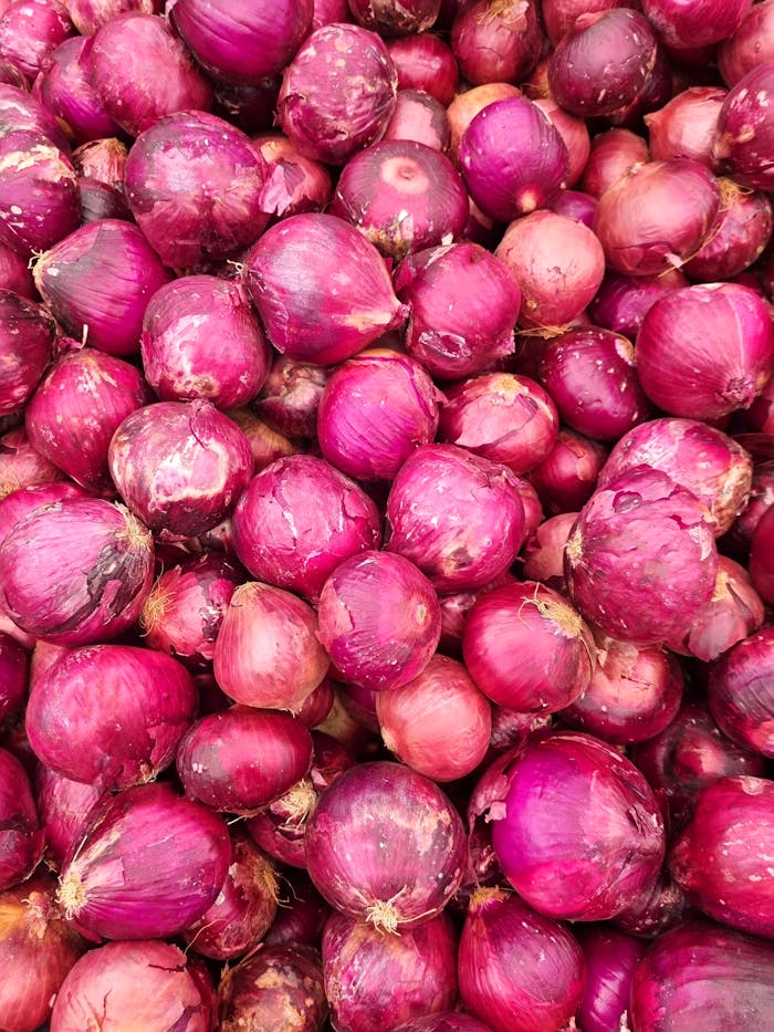 Ein lebendiges Foto, das einen Haufen frischer roter Zwiebeln auf einem Markt in Brasilien zeigt.